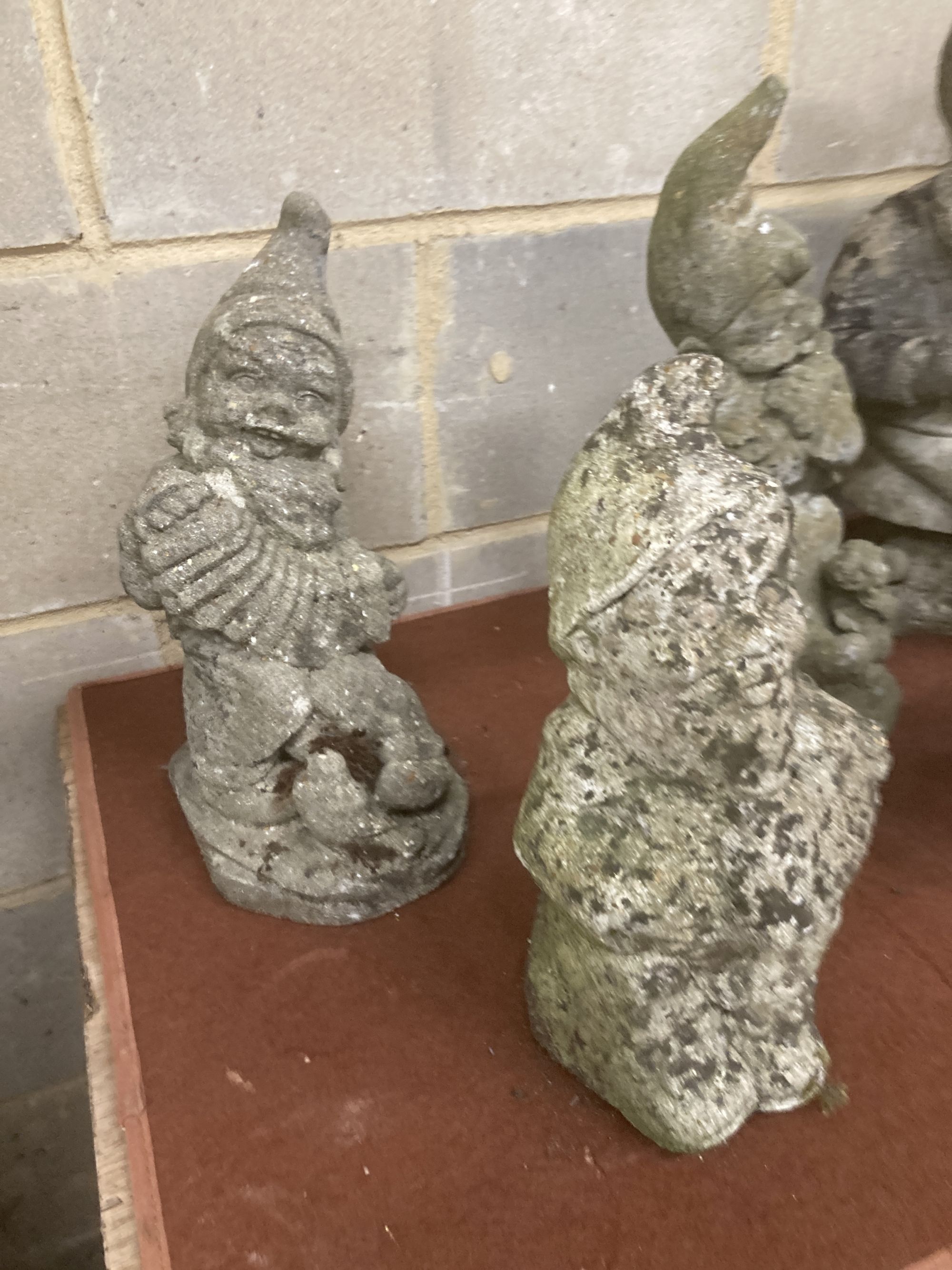 Six reconstituted stone gnome garden ornaments, largest 60cm high